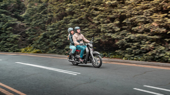 Honda Super Cub C125 op de baan met bijrijder.